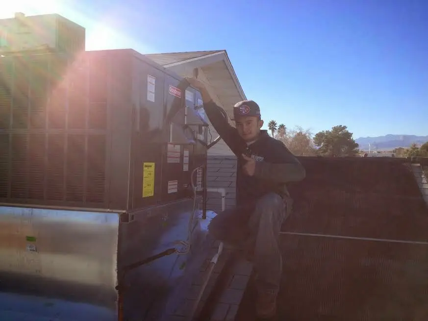 HVAC technician performing AC Tune-Up on a rooftop unit in Marina